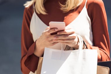 kısmi görmek smartphone kullanarak kağıt poşet olan kadın