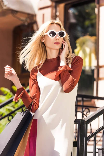 Bela Mulher Loira Óculos Sol Segurando Sacos Compras Falando Por — Fotografia de Stock