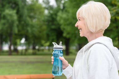 spor şişe tutan mutlu üst düzey kadın portresi profili