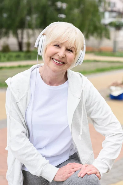 Улыбающаяся Пожилая Женщина Слушает Музыку Наушниках — стоковое фото