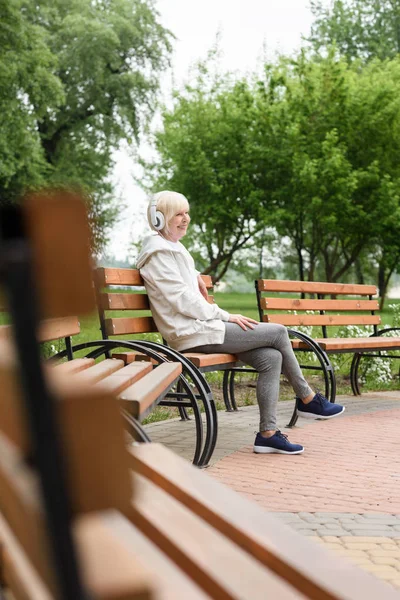 Старшая Женщина Слушает Музыку Наушниках Скамейке Парке — стоковое фото
