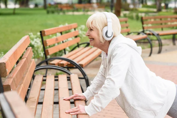 Senior Sportig Kvinna Hörlurar Utbildning Nära Bänkar Parken — Stockfoto