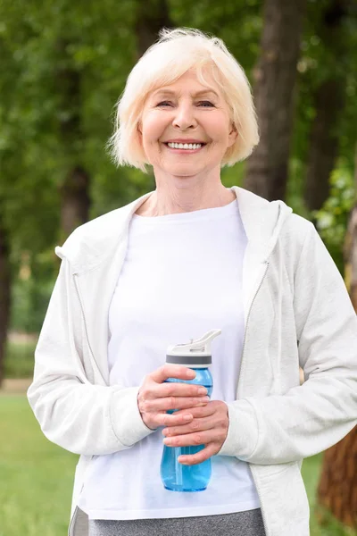 Smiling Senior Sportswoman Holding Water Sport Bottle — Free Stock Photo