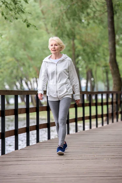 Senior Kvinna Sportkläder Trä Sökväg Parken Nära Floden — Stockfoto