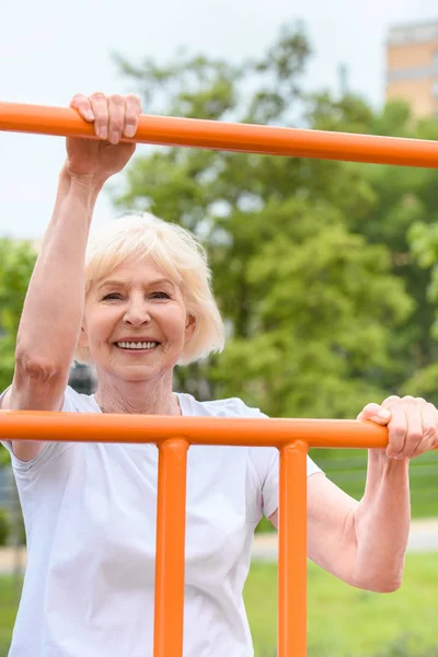 Smiling Senior Sportswoman Exercising Sports Ground — Stock Photo, Image