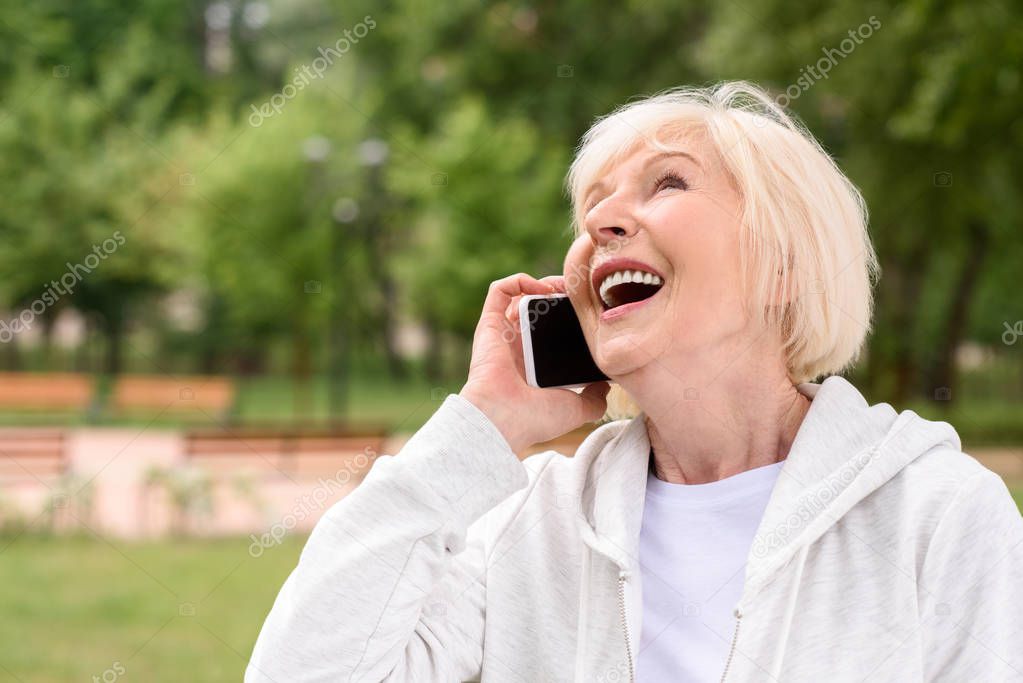 laughing elderly woman talking on smartphone