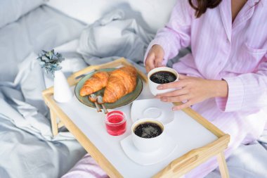 kadın Pembe pijama yatakta kahvaltı görünümünü kırpılmış