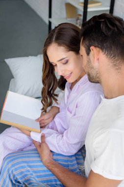 Genç mutlu çift kucaklayan ve birlikte kitap okuma