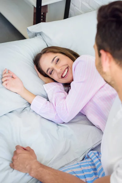 Обрезанный Снимок Молодого Человека Смотрящего Счастливую Девушку Лежащую Кровати — Бесплатное стоковое фото