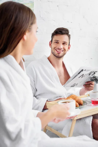Young Family Bathrobes Having Breakfast Reading Newspaper Bed — Free Stock Photo