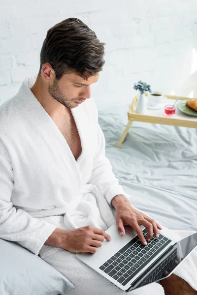 Young Man Bathrobe Sitting Bed Using Laptop — Free Stock Photo