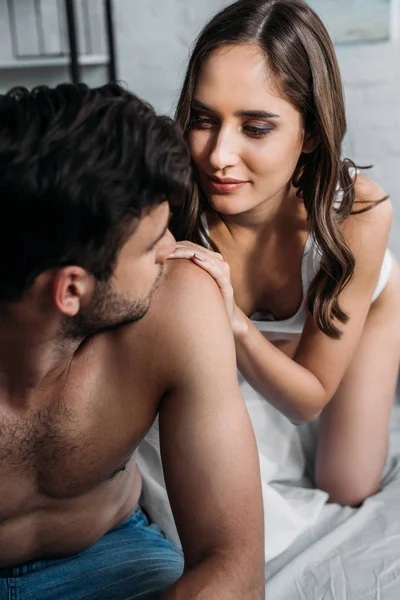 朝のベッドの上の彼の肩に触れることで彼氏を見て魅力的なガール フレンド — ストック写真