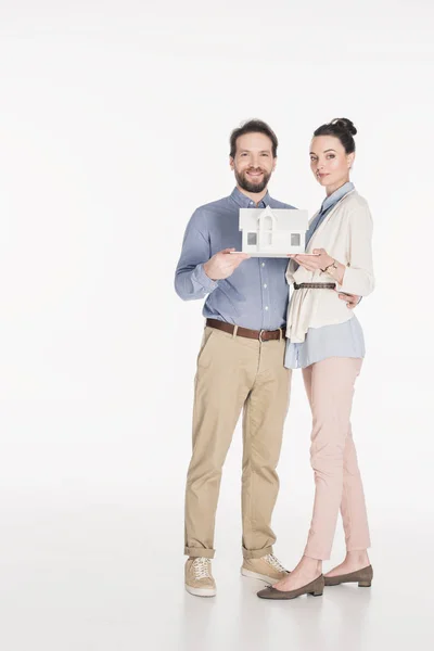 Sorrindo Casal Com Modelo Casa Olhando Para Câmera Isolada Branco — Fotografia de Stock