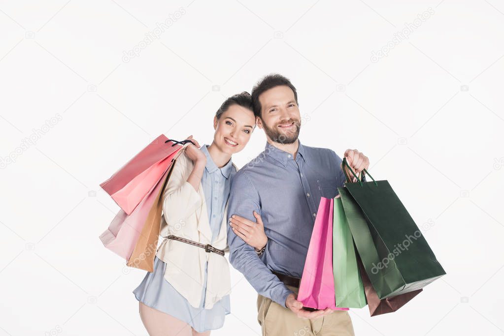 portrait of cheerful couple with shopping bags isolated on white