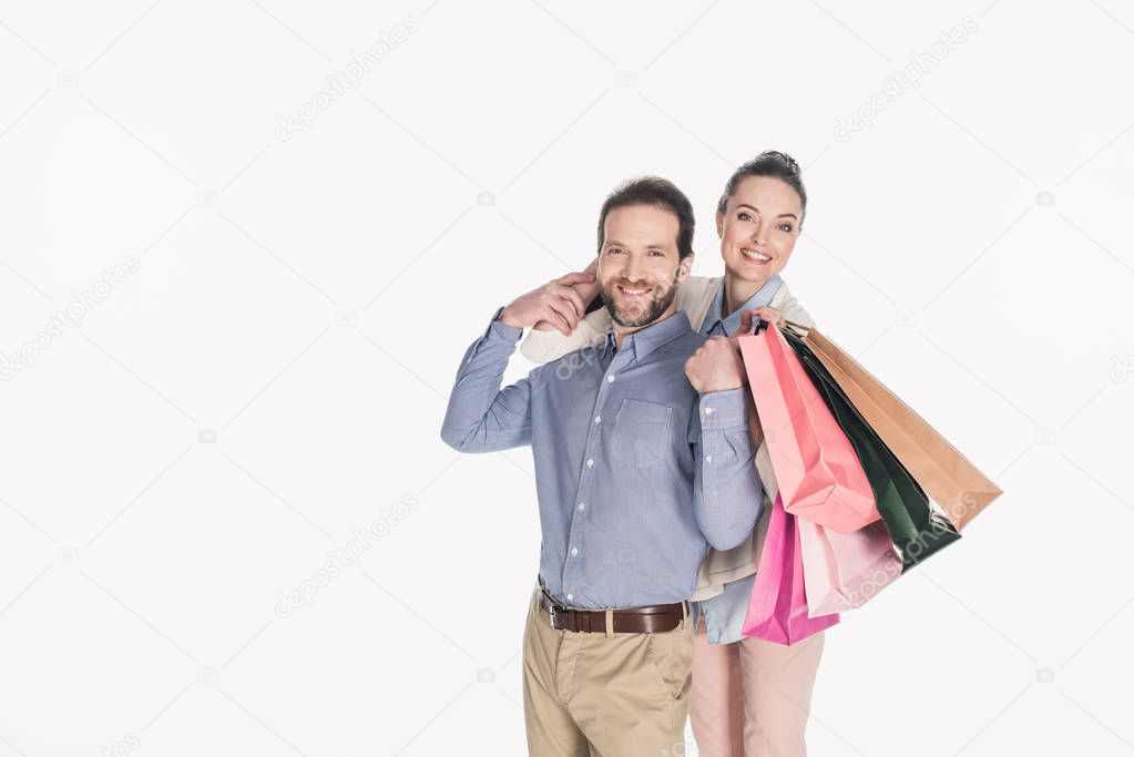 cheerful couple with shopping bags isolated on white