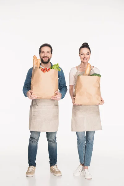 Assistentes Loja Alegres Aventais Que Mantêm Pacotes Papel Com Comida — Fotografia de Stock