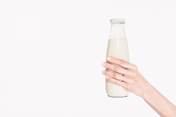 cropped shot of woman holding glass bottle of milk isolated on white