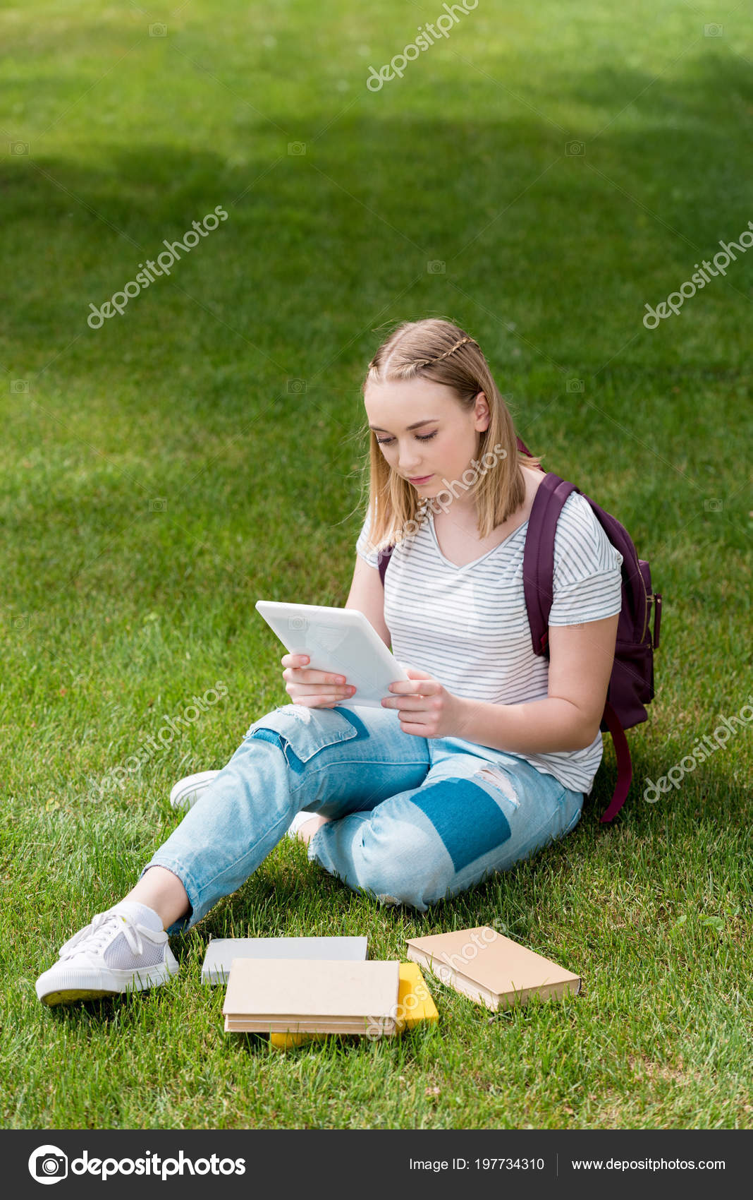 Adolescent Étudiant Fille Utilisant Tablette Tout Étant Assis Sur L'herbe  image libre de droit par IgorVetushko © #197734310