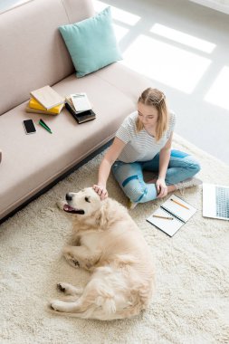 güzel genç kız köpeğini ödev yaparken sevişme yüksek açılı görünüş