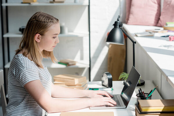 teen student girl working with laptop at home