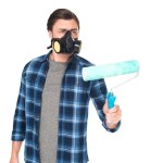 Mannen i respirator med paint roller isolerad på vit bakgrund