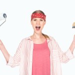 Screaming woman in headband holding paint roller and paint brush isolated on white background