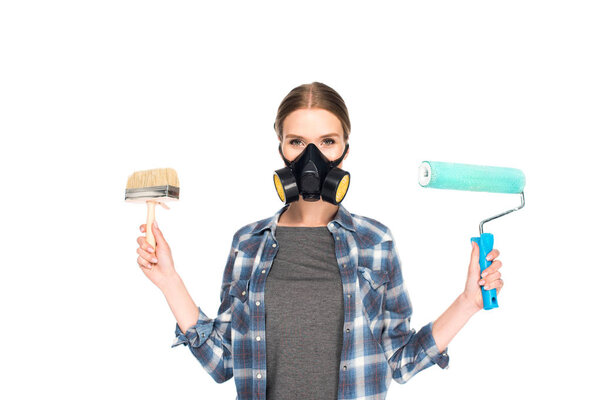 woman in respirator holding paint brush and paint roller isolated on white background 