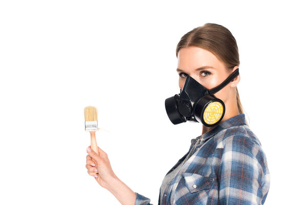 young woman in respirator holding paint brush isolated on white background 