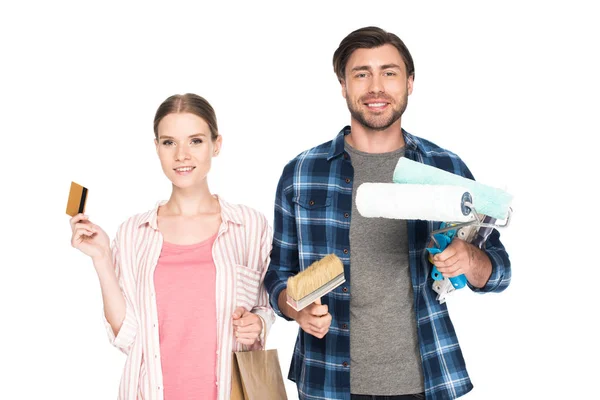 stock image smiling couple with credit card, shopping bag and painting tools isolated on white background 