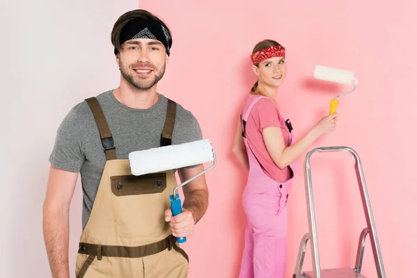 Smiling Man Paint Roller His Girlfriend Standing Painting Wall — Free Stock Photo