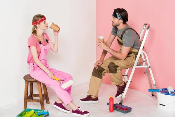 Side View Couple Working Overalls Sitting Drinking Coffee Room Painting — Free Stock Photo