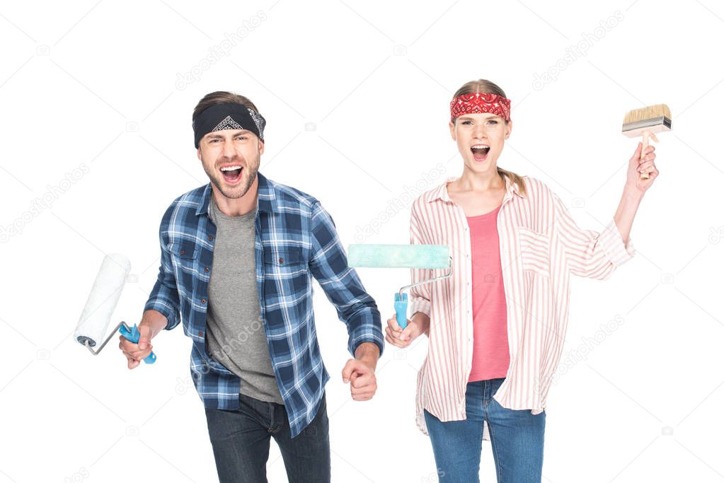 happy screaming couple in headbands with paint rollers and paint brush isolated on white background 