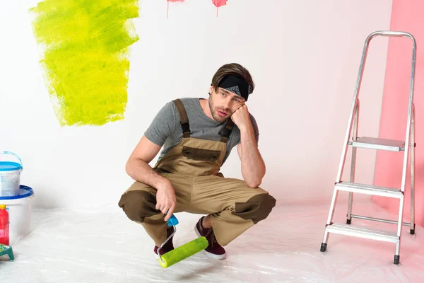 Jovem Cansado Sentado Com Rolo Pintura Perto Escada Frente Parede — Fotografia de Stock