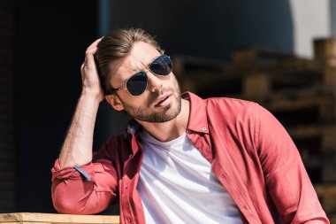 portrait of stylish young man in sunglasses holding hand on haircut  clipart