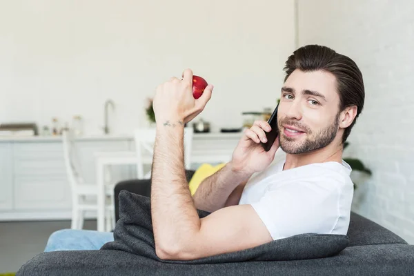 Smiling Man Talking Smartphone Sitting Couch Apple Hand Home — Free Stock Photo