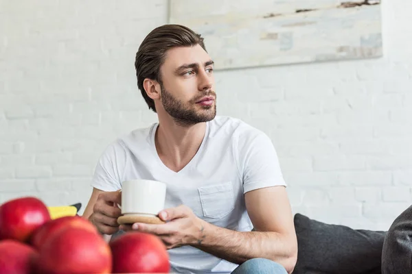 Young Man Sitting Couch Coffee Cup Table Apples — Free Stock Photo