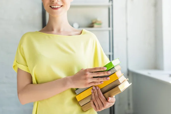 Bijgesneden Afbeelding Van Lachende Jonge Vrouw Met Stapel Boeken — Stockfoto