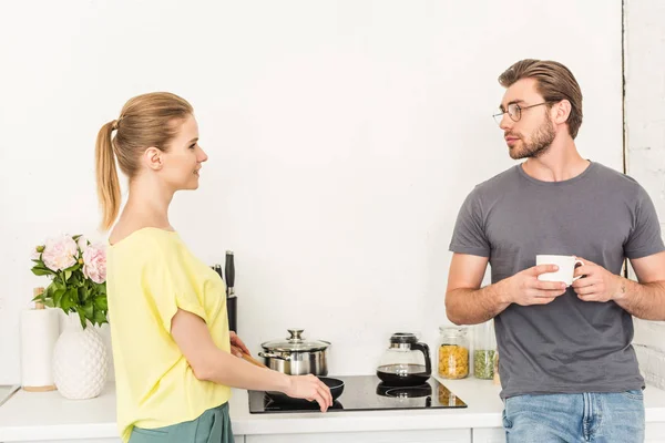 Side View Smiling Woman Cooking Stove Talking Boyfriend Coffee Cup — Free Stock Photo