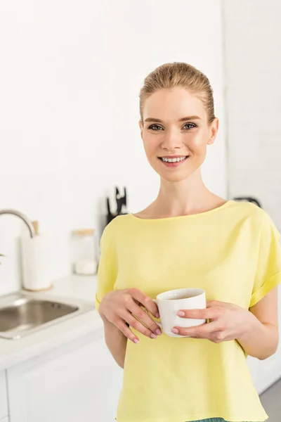 Jonge Lachende Vrouw Houden Van Koffiekopje Keuken — Gratis stockfoto