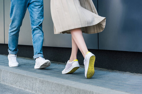 cropped image of stylish man in jeans and woman in long skirt 