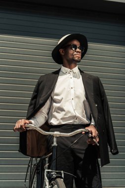 Moda Afrikalı-Amerikalı adam bisiklet tutan fedora şapka