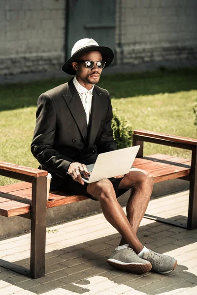 Bonito Jovem Afro Americano Trabalhando Laptop Enquanto Sentado Banco — Fotografia de Stock