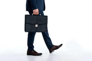 low section of businessman holding briefcase and walking on white  clipart