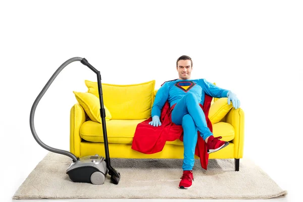 ゴム手袋掃除機近くのソファに座っていると 白で隔離カメラ目線で笑顔の男性ヒーロー — ストック写真