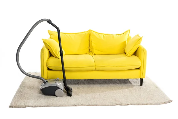 Bright yellow sofa and vacuum cleaner on carpet isolated on white — Stock Image Bright Yellow Sofa Vacuum Cleaner Carpet Isolated White Stock Image