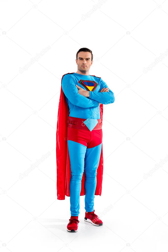 full length view of confident handsome superman standing with crossed arms and looking at camera isolated on white 