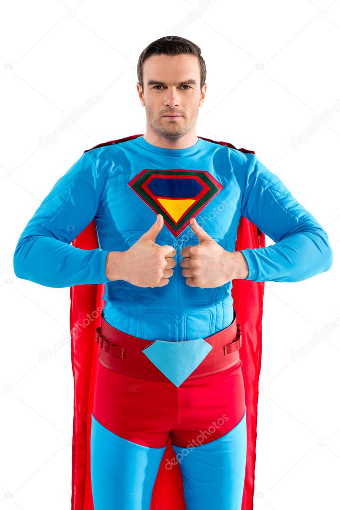 handsome male superhero showing thumbs up and looking at camera isolated on white