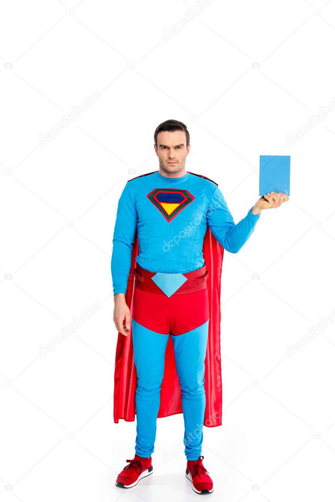 full length view of handsome superman holding soap powder and looking at camera isolated on white