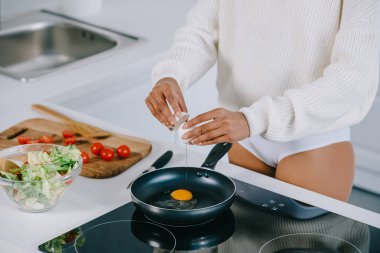 cropped shot of woman preparing scrambled egg for breakfast at kitchen