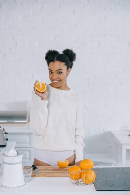 beautiful young woman with fresh oranges at kitchen